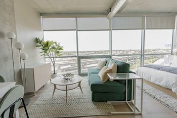 A living room with a green couch and a glass table.